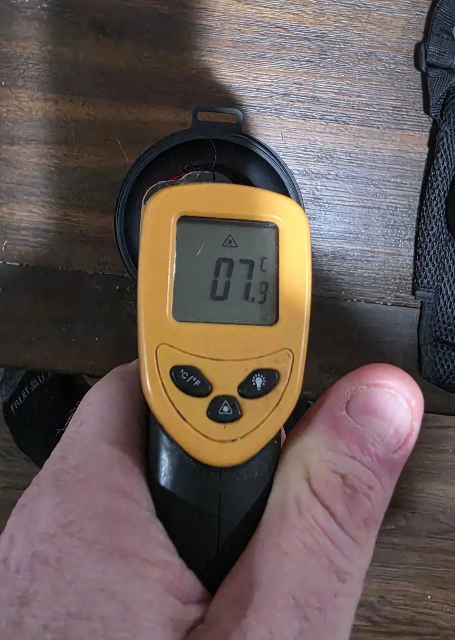 A handheld infrared thermometer displaying 7.9°C while aimed into the open, empty Svalto Cooler Pro immediately after the outdoor check.